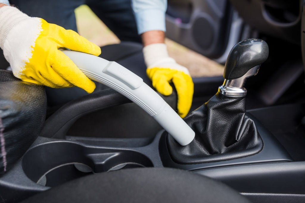 Detailing and cleaning car with vacuum cleaner. Car care concept.