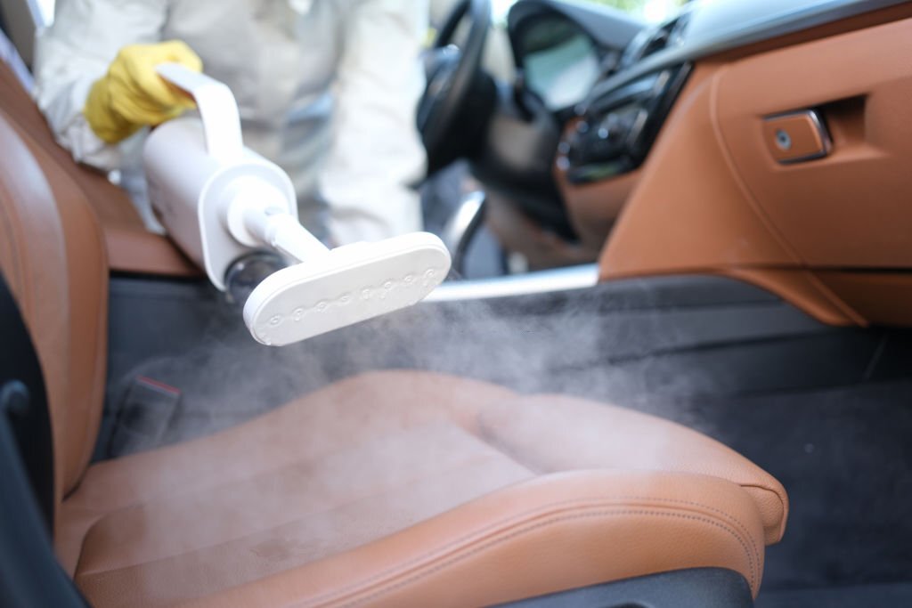 Steam cleaning and disinfection of car interiors and car seats with steam cleaner. Car interior cleaning concept