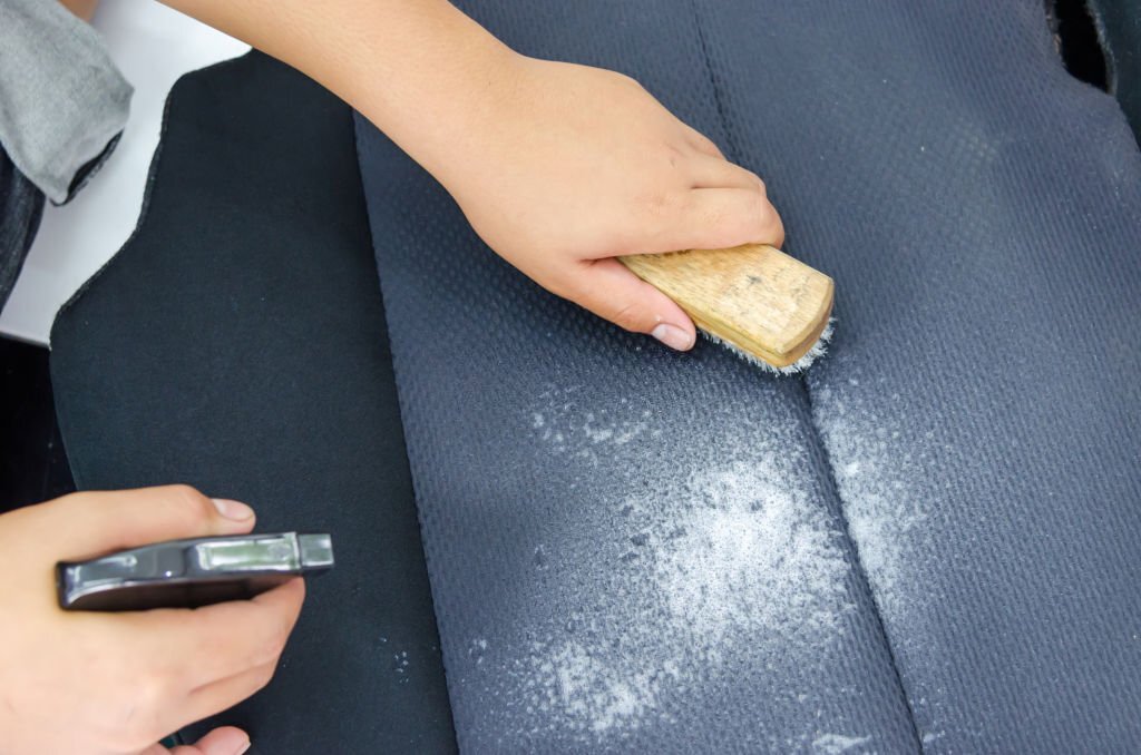 man with a hand to scrub brush to clean upholstery