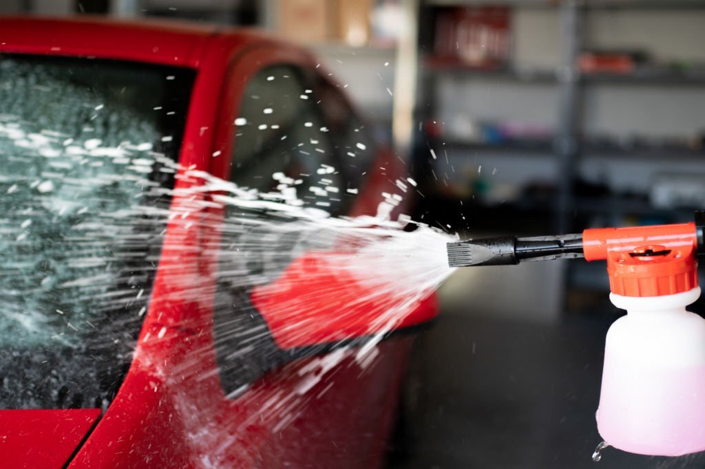 Red vehicle cleaning with pressure foam gun