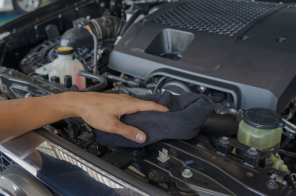 Mechanic checks and cleans the car's engine.