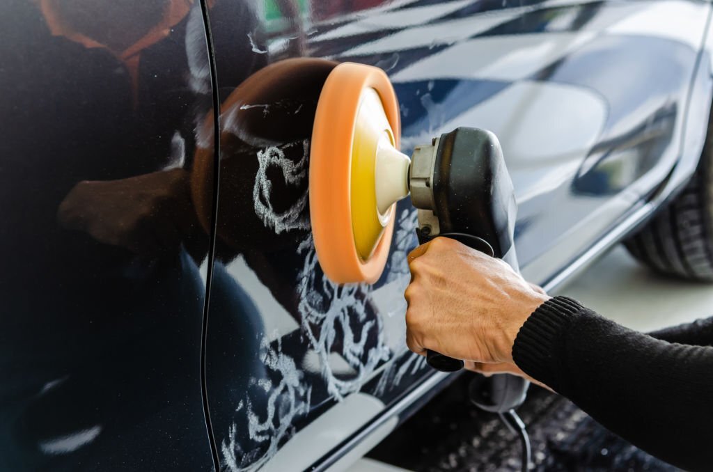 A man's hands holding the work tool polish the car.